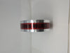 Close-up of a metallic utility tape roll featuring a red center stripe with the black printed text CAUTION BURIED E and silver reflective edges.