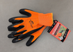 A pair of orange high-visibility knit work gloves with black latex foam palm coating and elasticized cuffs, shown with an attached product hang tag.